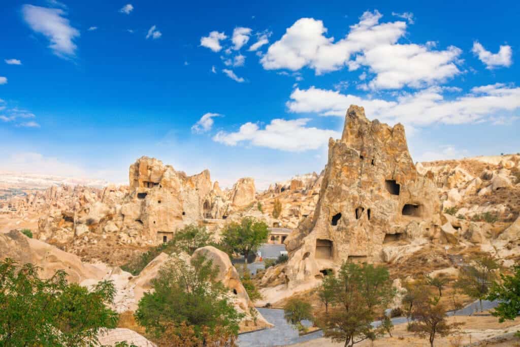 Ancient cave churches and rock-cut monasteries at Göreme Open-Air Museum in Cappadocia under a bright blue sky.