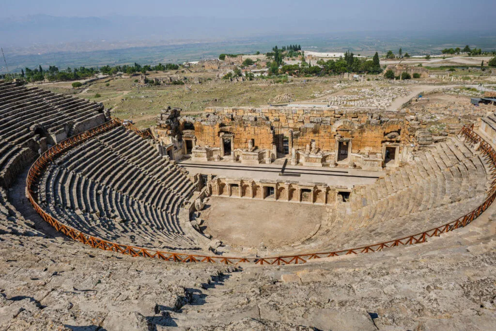 Panoramic view of the Ancient Theatre of Hierapolis in Pamukkale, Turkey, with stone seating and preserved Roman stage.