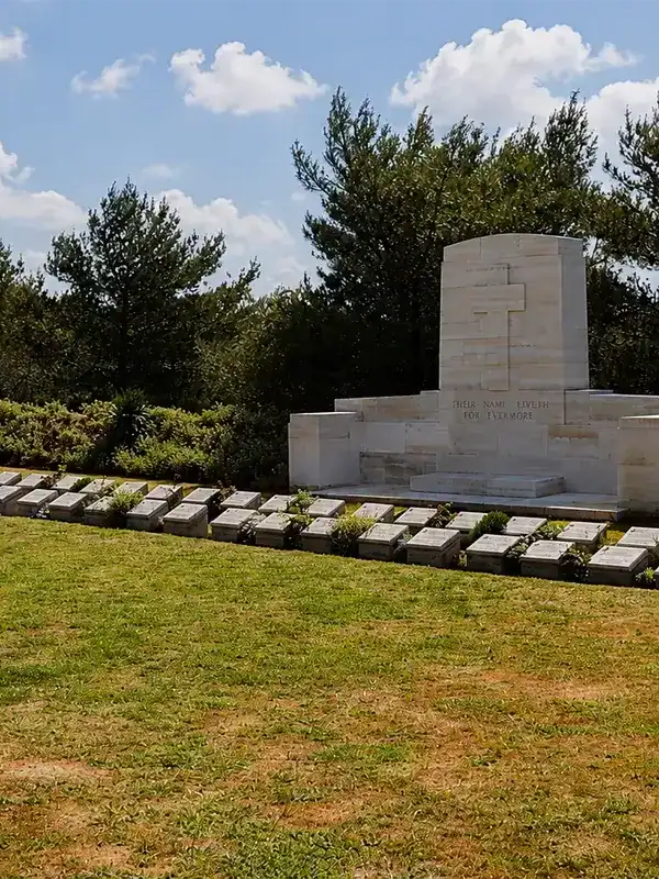 Johnston's Jolly Gallipoli memorial cemetery with white stone graves and monument surrounded by pine trees