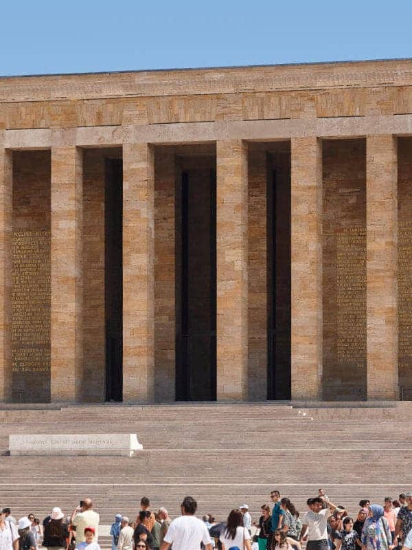 Crowds at Anıtkabir, the grand mausoleum of Mustafa Kemal Atatürk in Ankara, with tall columns and stone facade.