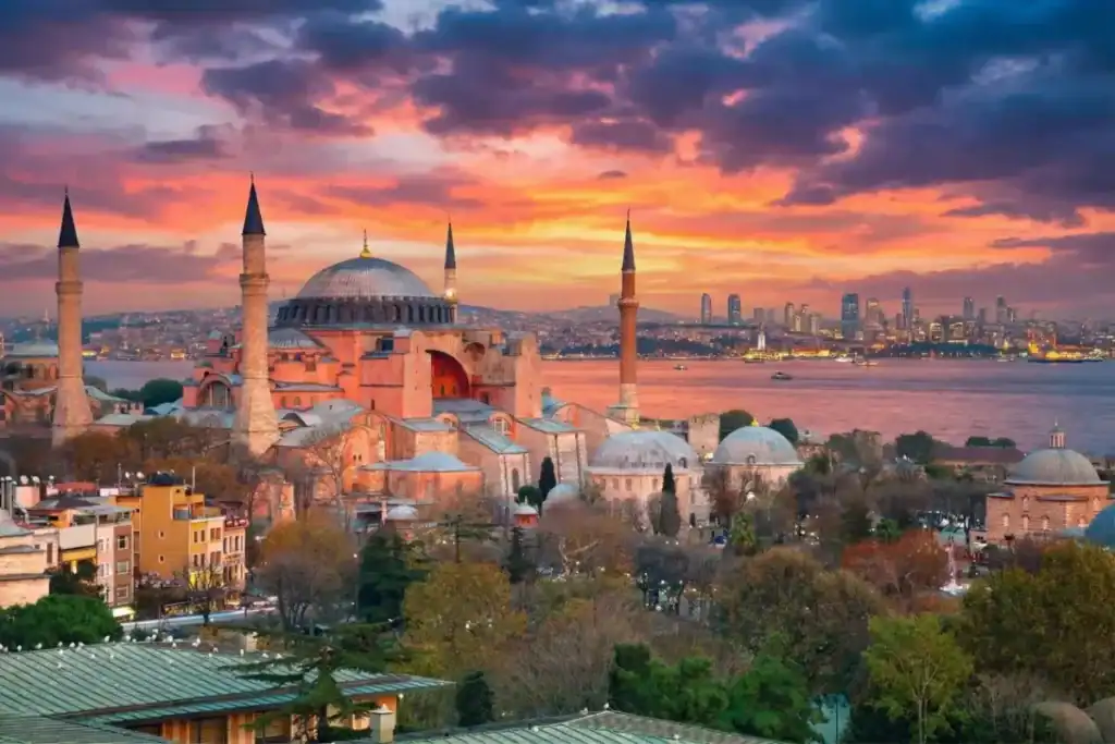 Scenic view of the Hagia Sophia Grand Mosque in Istanbul at sunset overlooking the Bosphorus Strait and city skyline.
