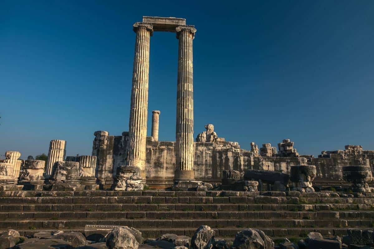 Ancient Temple of Apollo ruins in Didyma, Aydın, Turkey, with tall stone columns and steps under a clear blue sky.